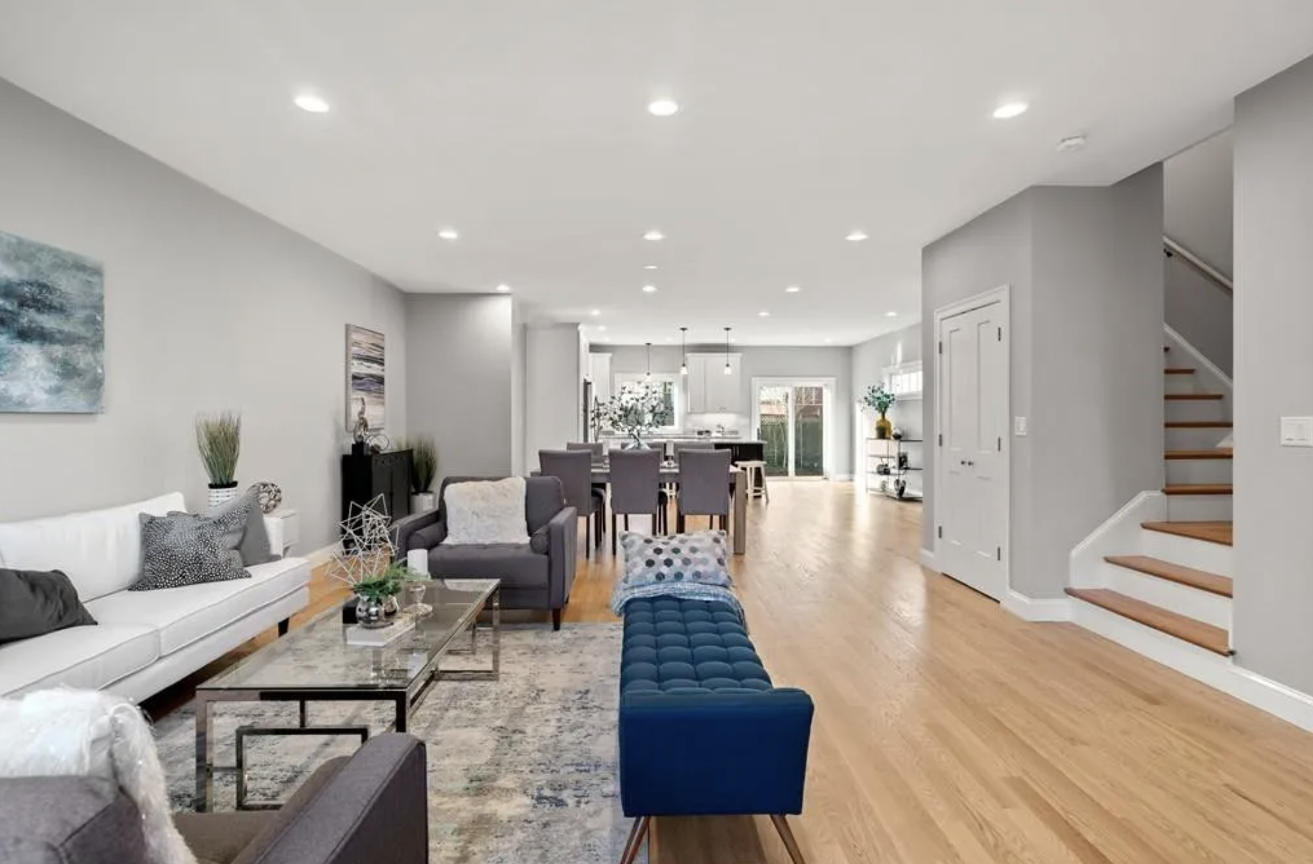 Bright, open-concept living and dining space with hardwood floors by Ferragamo Custom Builders